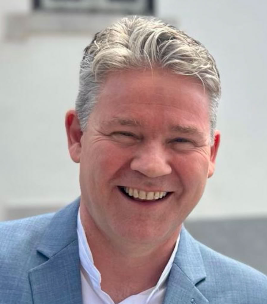 Young call center agent wearing a headset and working on a laptop in an office setting.
